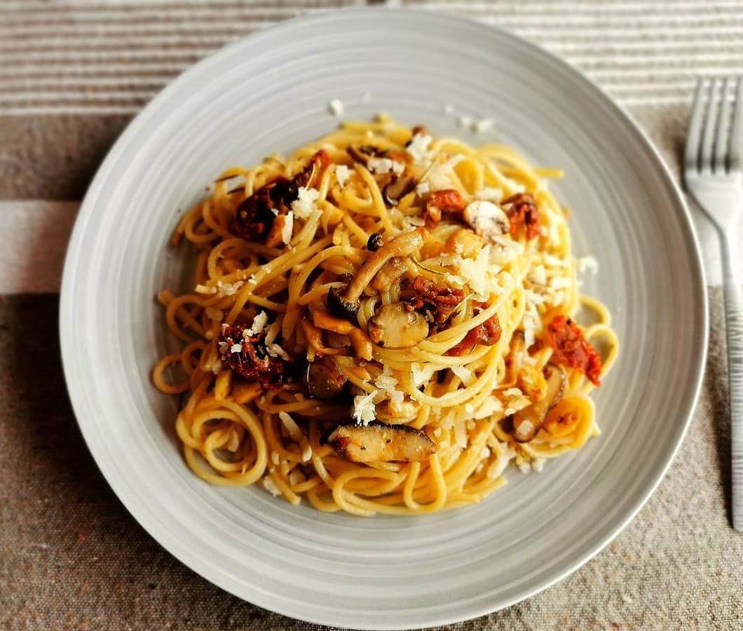 Espaguetis con tomates secos, setas y almendras
